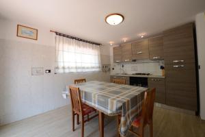 a kitchen with a table and chairs and a kitchen with a counter at Appartamento Pietri in Marina di Campo