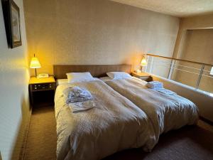 a hotel room with a large bed with towels on it at Ohta Grand Hotel in Ota