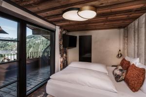 a bedroom with a bed and a balcony at NANI - Mountain Chalet in Saalbach-Hinterglemm