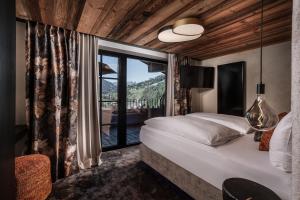 a bedroom with a bed and a large window at NANI - Mountain Chalet in Saalbach-Hinterglemm