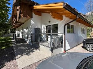 a house with a balcony and a car parked in front at Casa Vian in Vigo di Fassa
