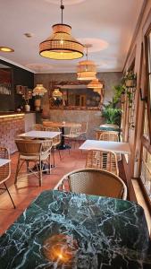 ein Restaurant mit Tischen und Stühlen und einer Bar in der Unterkunft Hotel Pugide in Llanes