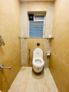 a small bathroom with a toilet with a window at ConnektHomes - Modern2Bed-BandraArea in Mumbai +26 photos