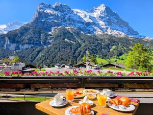 a table with food on it with a mountain view at Hotel Bernerhof Grindelwald in Grindelwald