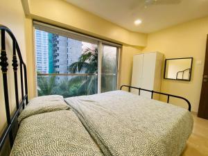 a bedroom with a bed and a large window at ConnektHomes - Modern2Bed-BandraArea in Mumbai