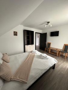 a bedroom with a large bed and a living room at Casa Tică in Vama Buzăului