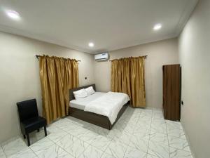 a bedroom with a bed and a chair in it at MerryJay Hotels in Otta