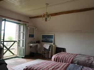 a bedroom with a bed and a table and a window at Cottage LAISSER VERDURE in Gargilesse-Dampierre