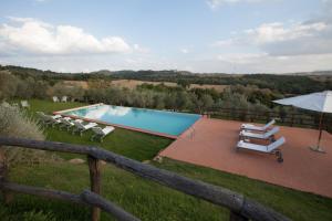 a patio area with a pool and lawn chairs at Borgo Sant'Ambrogio - Resort in Pienza