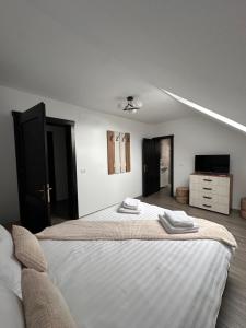 a bedroom with a bed with two towels on it at Casa Tică in Vama Buzăului