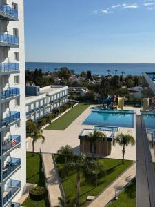 an aerial view of a building with a swimming pool and the ocean at Royal Life Poseidon Residences Long Beach in Iskele