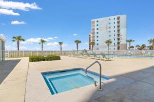 a swimming pool with chairs and a building at Perdido Sun 1008 in Perdido Key