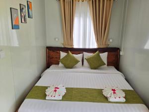 a bedroom with a bed with two pillows on it at Green House 168 in Kaôh Rŭng (3) +17 photos