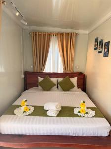 a bedroom with a large bed with flowers on it at Green House 168 in Kaôh Rŭng (3)