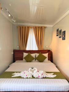 a bedroom with a bed with two towels on it at Green House 168 in Kaôh Rŭng (3)