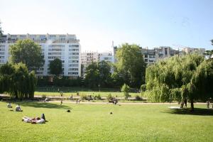 people laying on the grass in a park at Porte de Paris, spacieux T3, terrasse et parking in Vanves