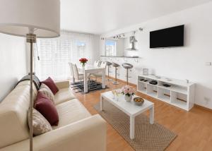 a white living room with a couch and a table at Porte de Paris, spacieux T3, terrasse et parking in Vanves