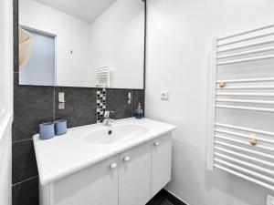 a bathroom with a white sink and a mirror at Porte de Paris, spacieux T3, terrasse et parking in Vanves +24 photos
