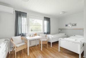 a bedroom with two beds and a table and chairs at FolkiaCenter Gästhem - Vieraskoti - Guesthouse in Hanko