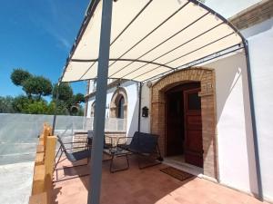 a pergola on a patio with a table and chairs at casale nonna Elisa relax tra ulivi in San Vito Chietino