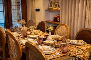a long table with plates and bowls of food on it at The Riverside Barn Srinagar in Srinagar