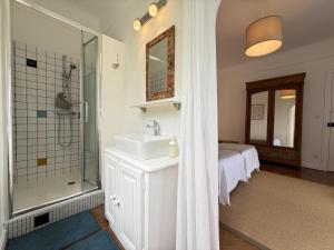 a bathroom with a sink and a shower and a bed at Gure gostuan in Itxassou