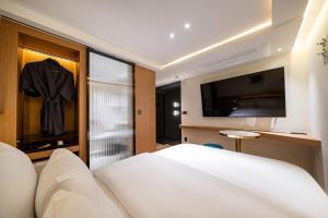 a bedroom with a bed and a flat screen tv at 천호 호텔 코드 in Seoul