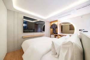 a bedroom with a white bed and a mirror at 천호 호텔 코드 in Seoul