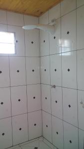 uma casa de banho com paredes em azulejos brancos e uma janela em Alto Mar Flats em São Miguel do Gostoso