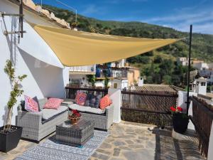 a patio with couches and a canopy on a balcony at El Pequeño Escondite in Torviscón