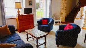 a living room with two chairs and a table at La Maison des Filles in Sainte-Scolasse-sur-Sarthe