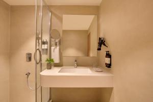 a bathroom with a sink and a shower at Regenta Place CG Road in Ahmedabad +26 photos