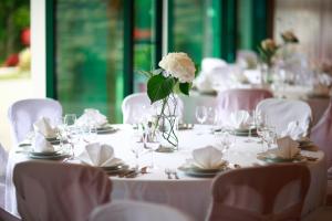 a table with a vase with a white flower on it at Guesthouse Villa Zelenjak Ventek in Kumrovec