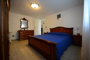 マリーナ・ディ・カンポにあるAppartamento Pietriのベッドルーム1室(ベッド1台、ドレッサー、鏡付)