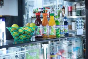 a shelf with bottles of drinks and a bowl of fruit at SRL Grand Residency in Tirupati
