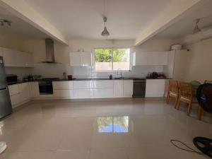 a large kitchen with white cabinets and a table at Blacvine in La Gaulette