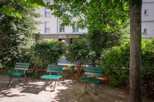 three green chairs sitting in front of a building at Central Hotel Paris in Paris