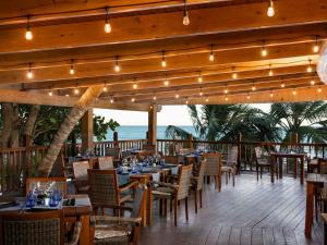 a restaurant with tables and chairs and the ocean at Impressive Premium Punta Cana - All Inclusive in Punta Cana