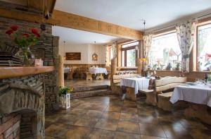 un restaurant avec deux tables et un mur en pierre dans l'établissement Willa Borowianka, à Zakopane