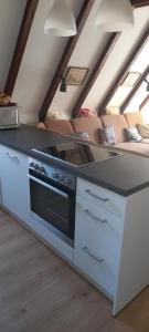 a kitchen with a stove and a couch in a room at Ferienpark Vorauf Typ B/Oslo Wacholderweg 10 in Siegsdorf