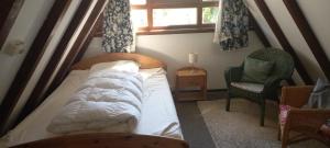 a bedroom with a bed and a chair and a window at Ferienpark Vorauf Typ B/Oslo Wacholderweg 10 in Siegsdorf