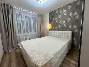 a bedroom with a white bed and a window at Central cozy apartments- one and two bedrooms option in Chişinău