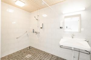 a white bathroom with a sink and a shower at FolkiaCenter Gästhem - Vieraskoti - Guesthouse in Hanko +36 photos