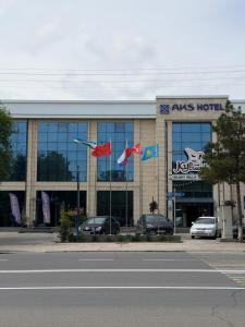 Aiss Hotel mit Flaggen vor einem Gebäude in der Unterkunft AKS Hotel in Taschkent