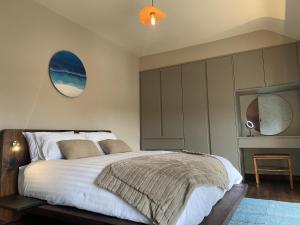a bedroom with a large bed and a mirror at The Loft at Design Bank in Milltown Malbay