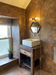 a bathroom with a sink and a mirror at The Loft at Design Bank in Milltown Malbay