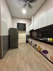 a large kitchen with a refrigerator in the middle at NovaStay Melaka in Kampong Kerubong +7 photos