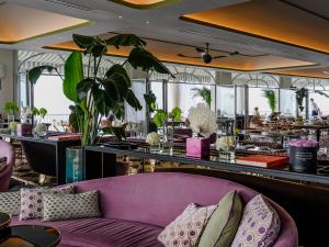 a purple couch in a restaurant with a bar at Hotel Miramalfi in Amalfi