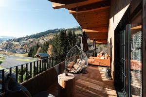 a porch with a hammock and a swing on a balcony at NANI - Mountain Chalet in Saalbach-Hinterglemm
