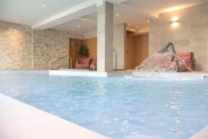a swimming pool with a fountain in a hotel at Hotel Collingwood BW Signature Collection in Bournemouth